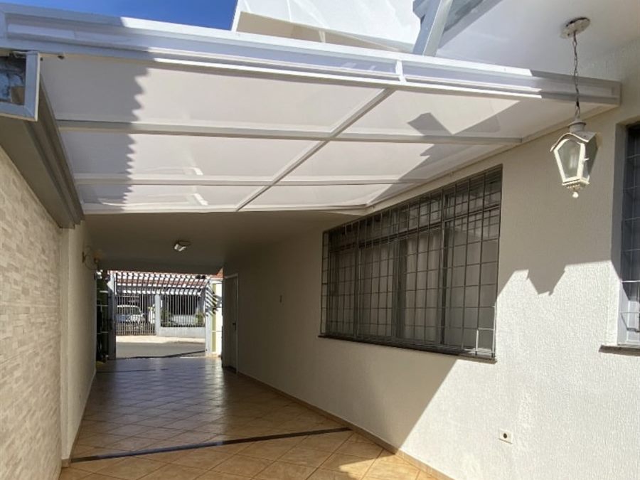 Cobertura de policarbonato branco sobre a garagem de uma casa